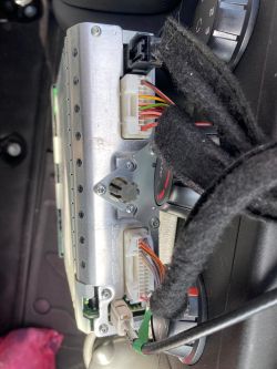 Rückansicht eines Autoradio-Steckers mit sichtbaren farbigen Drähten.