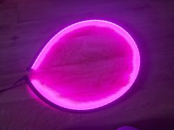 A pink LED strip light on the floor.
