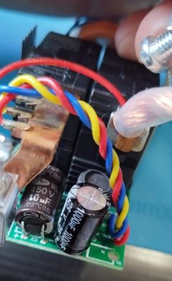 Close-up of an electronic circuit with colorful wires and capacitors.