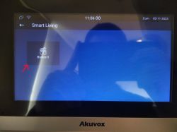 Ekran urządzenia Akuvox pokazujący aplikację Smart Living z przyciskiem “Button1”.