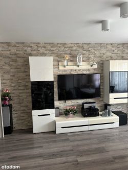Modern living room interior with a TV on a decorative stone wall.