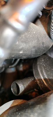 Zbliżenie na zaolejoną plastikową rurkę w komorze silnika Renault Clio
