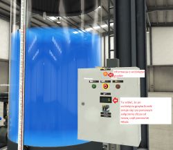 Elektroniczny panel kontrolny obok zbiornika z wodą w hali.