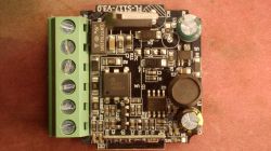 Close-up of a PCB with a green screw terminal block and various electronic components