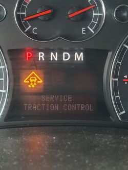 Wyświetlacz deski rozdzielczej pokazujący błąd SERVICE TRACTION CONTROL.