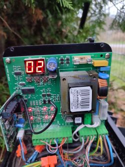 Zbliżenie na płytkę drukowaną z wyświetlaczem LED i różnymi elementami elektronicznymi.