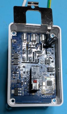 Electronic controller in an enclosure A printed circuit board of an electronic device inside a plastic case with a metal mounting bracket.
