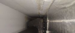 Interior of a fireplace with a black chimney pipe and metal casing.