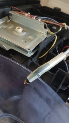 Wnętrze ekspresu do kawy z widoczną metalową obudową termobloku i podłączonymi rurkami oraz przewodami.