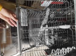 Wnętrze zmywarki z widoczną górną szufladą i ramieniem zraszającym