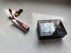 Bateria LiPo 450mAh wraz z ładowarką ToolkitRC M6 na białym tle.