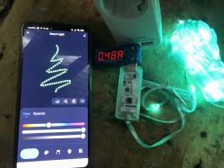 Smartphone displaying a Smart Light app next to glowing LED lights and a current measurement device.
