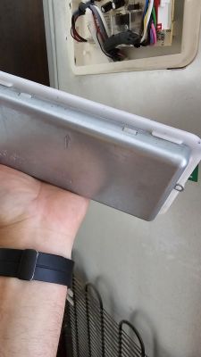 Osoba trzyma metalową pokrywę z plastikową obejmą.