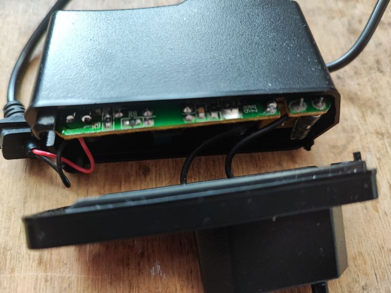 Otwarty obudowy zasilacza z widocznymi elementami elektronicznymi wewnątrz.