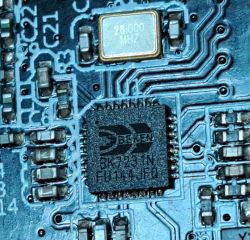 Close-up of a Bekcen BK7231N chip and 26 MHz quartz oscillator on a printed circuit board.