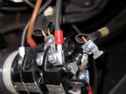 Zbliżenie na wnętrze przełącznika elektrycznego w spawarce z widocznymi przewodami.