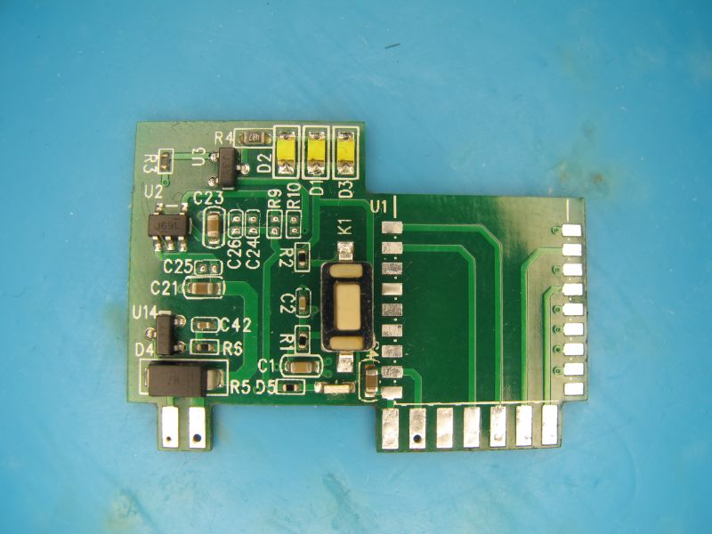 Green PCB with electronic SMD components on a blue background