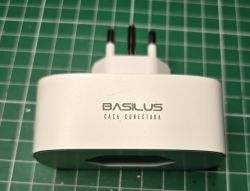 BASILUS Smart Plug on Green Grid Close-up of a BASILUS smart plug on a green grid.