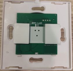 Printed Circuit Board in White Mounting Frame The image shows a printed circuit board mounted in a white plastic frame, with two white rectangular components.