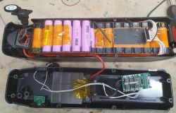 Otwarte wnętrze baterii bidonowej e-bike z widocznymi ogniwami i elektroniką.