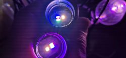 Two glowing LED lights in a dark setting
