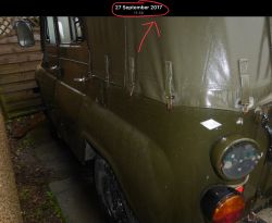 Zbliżenie na wojskowy pojazd terenowy z brezentowym pokryciem, sfotografowany z boku, z datą 27 września 2017 u góry.