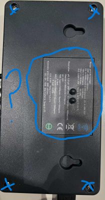 Back of black electronic device with marked label panel and mounting screws.