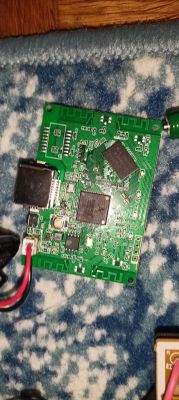 Zielona płytka PCB z układami scalonymi i gniazdem złącza, leżąca na niebieskim kocu