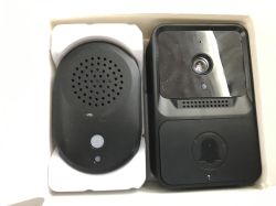 Two black devices: video doorbell and speaker module in cardboard box