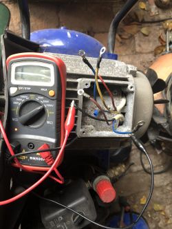 Multimetr i przewody podpięte do silnika elektrycznego.