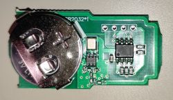 Close-up of a remote control circuit board with an installed CR2032 battery.