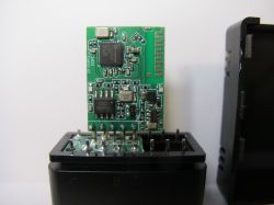 Circuit Board of TR6260S1 Module in OBDII Adapter Close-up of a circuit board with an electronic module inside a black adapter housing.