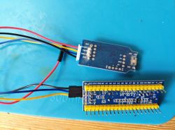 Connecting J-Link Programmer to STM32 Blue Pill Board J-Link programmer and STM32 blue pill board connected with jumper wires on a blue work mat.
