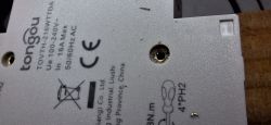 Close-up of the back of a Tongou electrical device with markings and mounting hole.