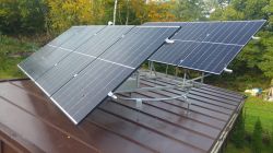 Photovoltaic Panels on Roof with Rotating Mechanism Photovoltaic panels mounted on a garage roof with a rotating mechanism.