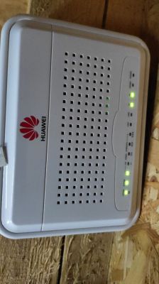 Modem Huawei B2338-168 z diodami sygnalizacyjnymi na drewnianej powierzchni