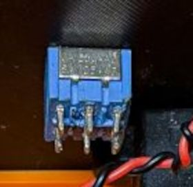 Blue DIP switch with eight pins on brown background