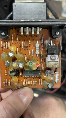 Zbliżenie na płytkę drukowaną z różnymi elementami elektronicznymi, w tym rezystorami i tranzystorem.
