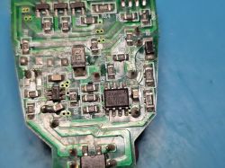 Zbliżenie płytki PCB z elementami SMD i układem scalonym w obudowie SOIC na niebieskim tle