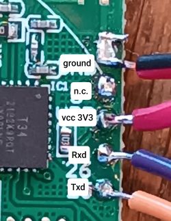 Connections on Circuit Board with T34 Chip Close-up of a circuit board with a T34 chip and connected wires at labeled pads: ground, n.c., vcc 3V3, Rxd, Txd.