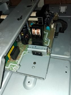Zbliżenie na wewnętrzny zasilacz urządzenia elektronicznego z widoczną elektroniką