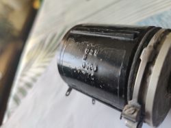 Zbliżenie czarnego cylindrycznego elementu z wytłoczeniami i metalowym pierścieniem z boku