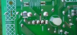 Tylna strona płytki PCB z widocznymi punktami lutowniczymi i oznaczeniami elementów elektronicznych.