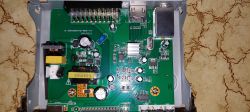 Inside of DVB tuner showing main PCB with capacitors, connectors, and electronic components