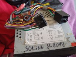 Tył samochodowego radia z wiązką przewodów i czarnymi złączami, na obudowie napis „SOLING SL 8018”.