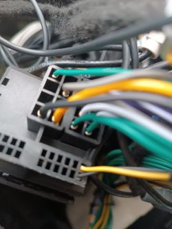 Zbliżenie na wiązkę przewodów podłączoną do czarnej wtyczki w instalacji samochodowej
