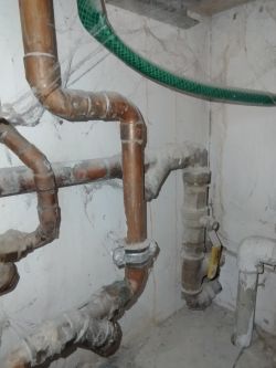 Rury instalacji hydraulicznej z zaworami przy piecu gazowym.