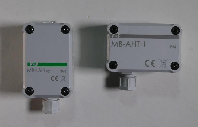 Dwa szare czujniki w prostokątnych obudowach z napisami MB-LS-1 v2 i MB-AHT-1 oraz oznaczeniem IP65.