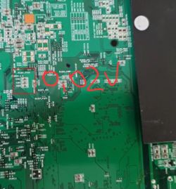 Fragment zielonej płytki PCB z oznaczeniem 0,02V zapisanym na zdjęciu czerwonym markerem
