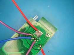 Circuit board with soldered wire connections PCB with soldered wires in various colors on a blue surface